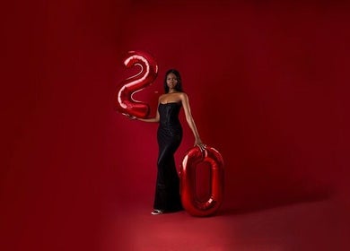 Stylish woman in black gown with balloons at Aidooklik, Accra, Greater Accra Region, GH.
