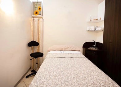 Stanza di trattamento accogliente presso Manuela Poloni - Padova, Padova, IT con letto e decorazioni floreali.