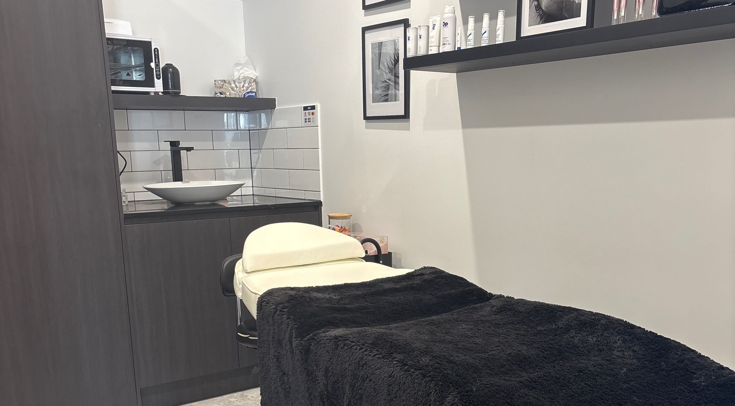 Cozy treatment room at Illusive Beauty, Nirimba, Queensland, AU with a massage table and stylish decor.