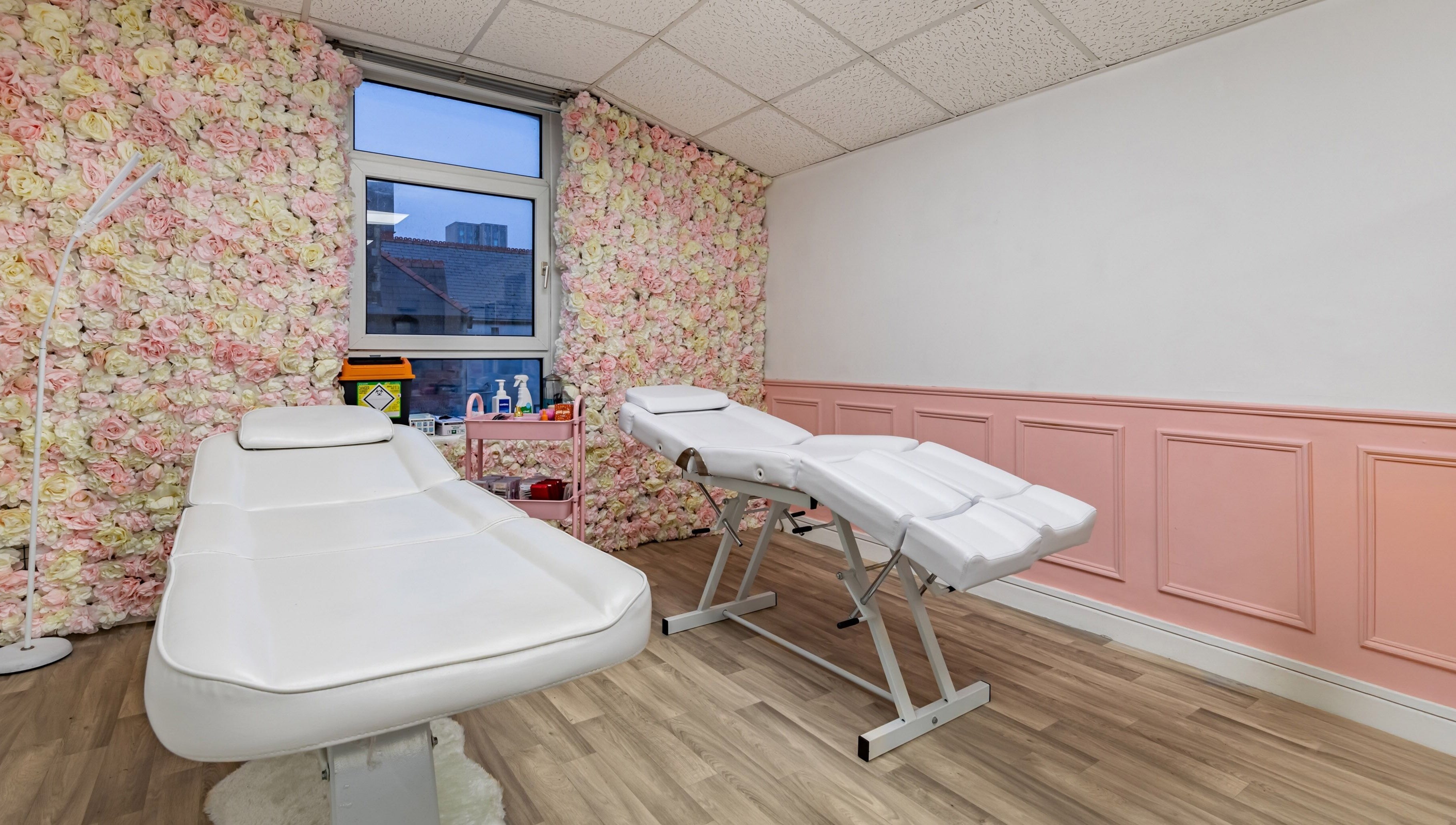 Elegant treatment room at Luxe Beautè, Cardiff, Wales, GB, with floral walls and comfortable treatment beds.