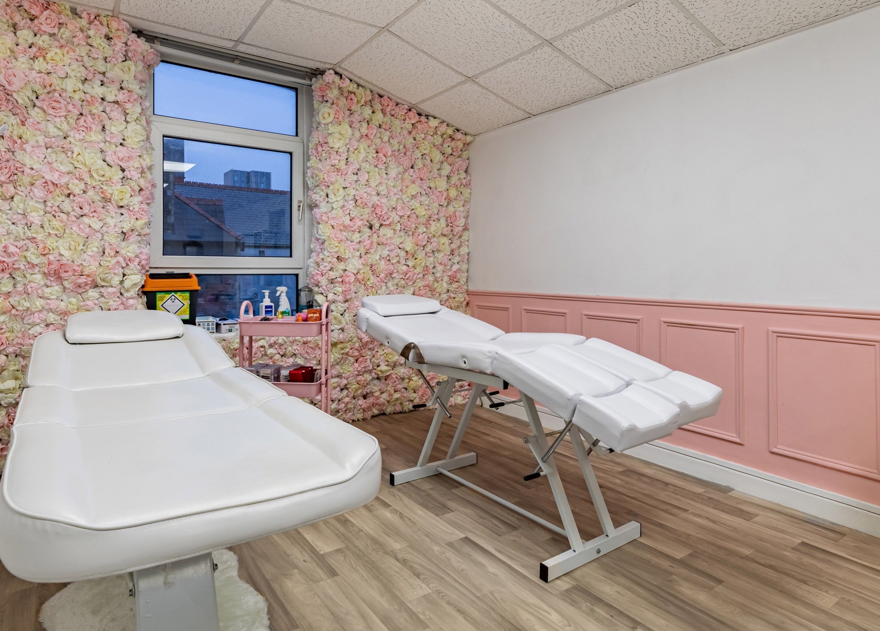 Elegant treatment room at Luxe Beautè, Cardiff, Wales, GB, with floral walls and comfortable treatment beds.