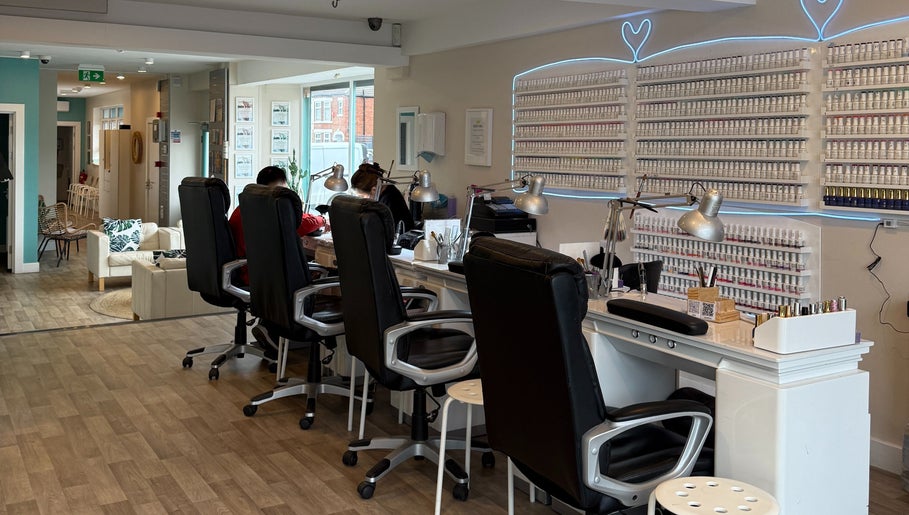 Queen Nails salon interior in Hull, England, GB featuring sleek nail stations and wall polish display.