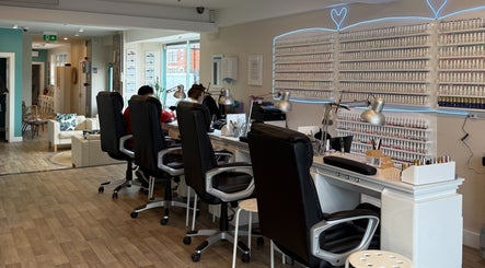 Queen Nails salon interior in Hull, England, GB featuring sleek nail stations and wall polish display.
