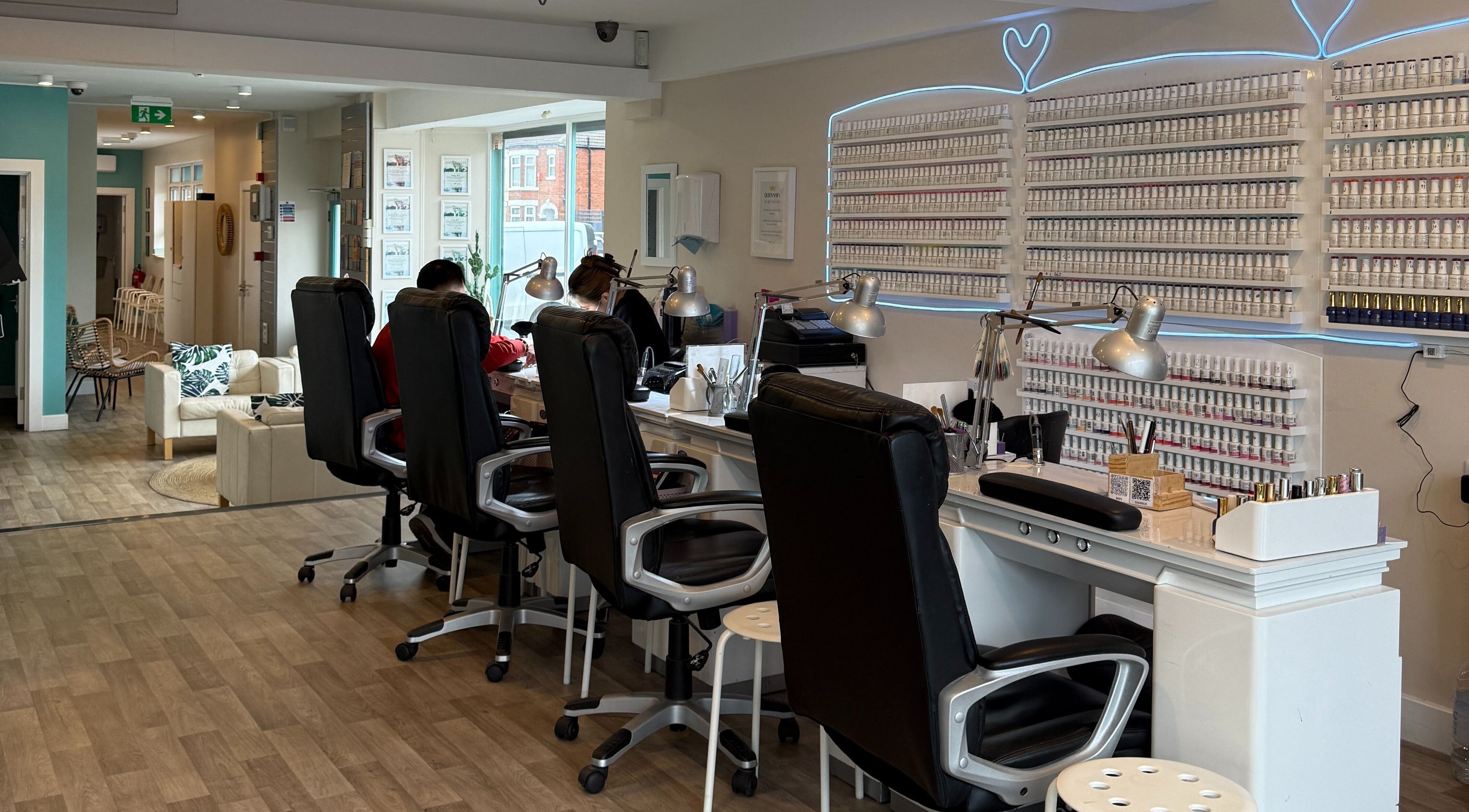 Modern interior of Queen Nails, Hull, England, GB, featuring nail stations and a vibrant polish display.