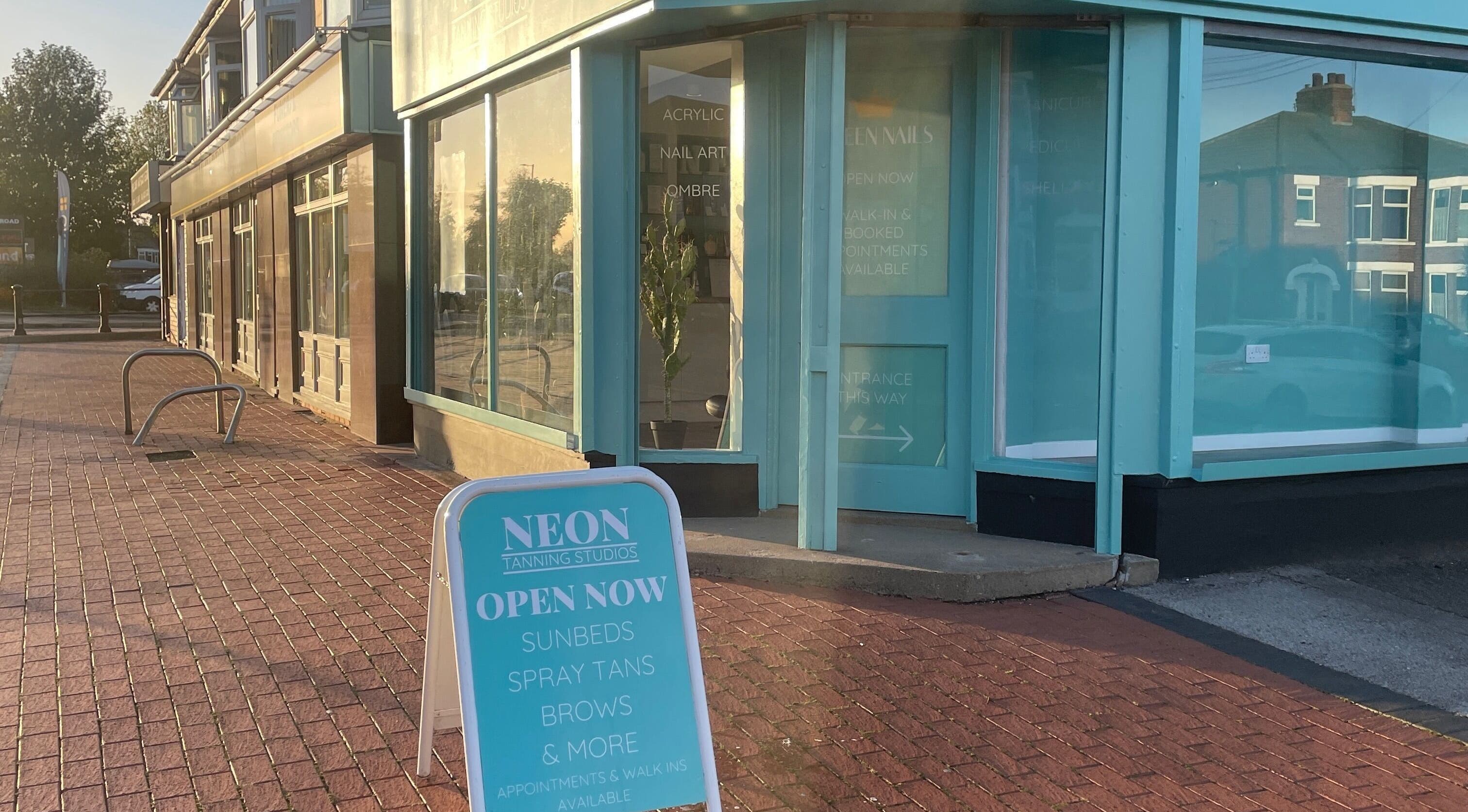 Entrance of Queen Nails, a chic beauty venue in Hull, England, GB, with signage advertising sunbeds and tanning.