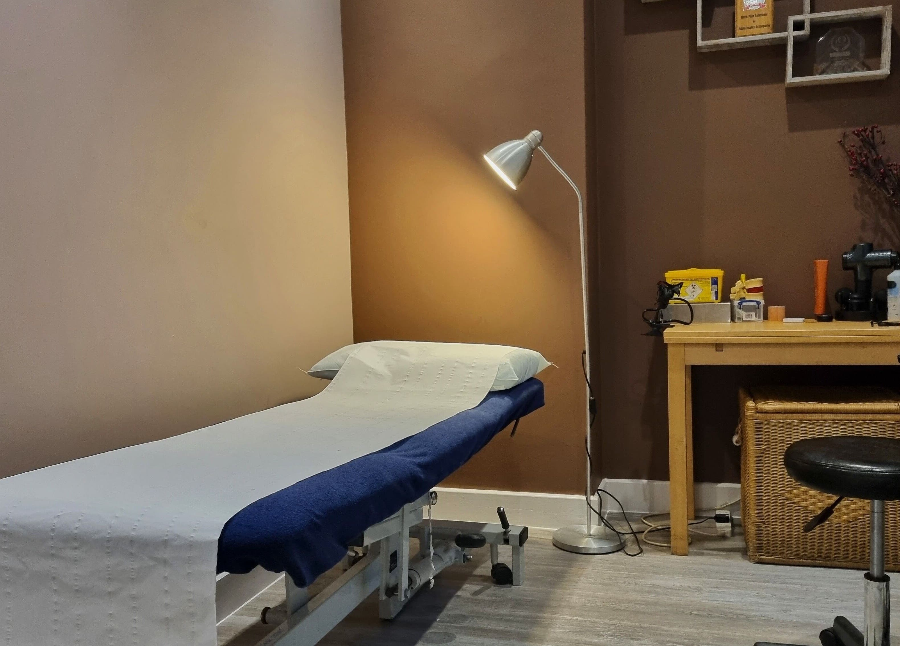 Cozy treatment room at Ginger Natural Health, St Albans, England, GB with massage table and decor.