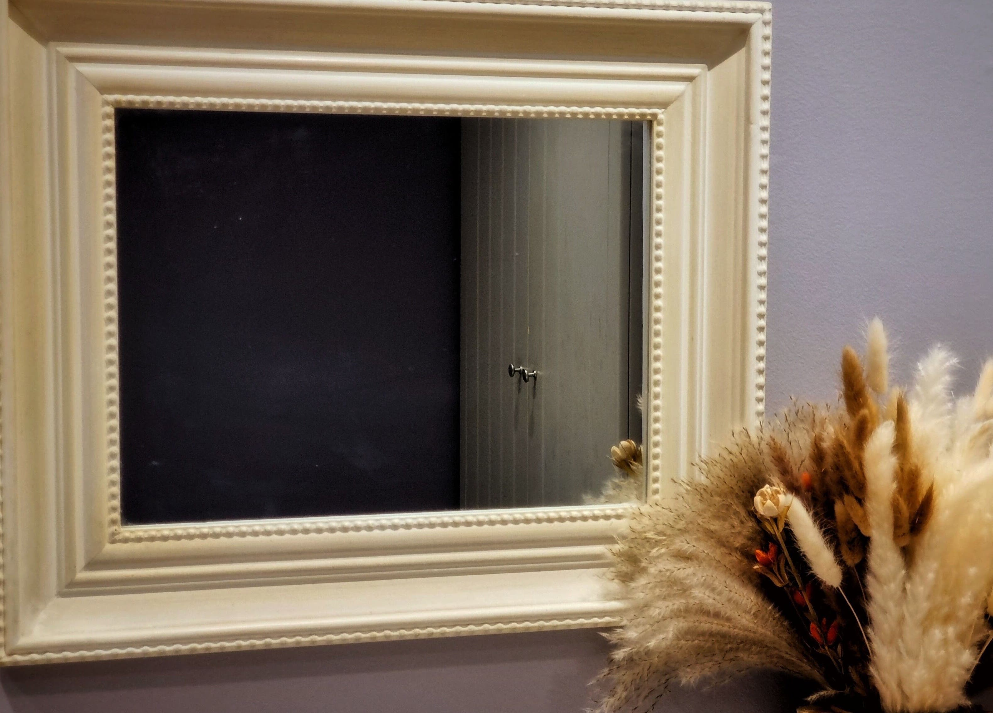 Elegant mirror with dried floral decor at Ginger Natural Health, St Albans, England, GB.