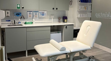 Modern treatment room at Skintap, London, England, GB with a comfortable spa bed and sleek cabinetry.