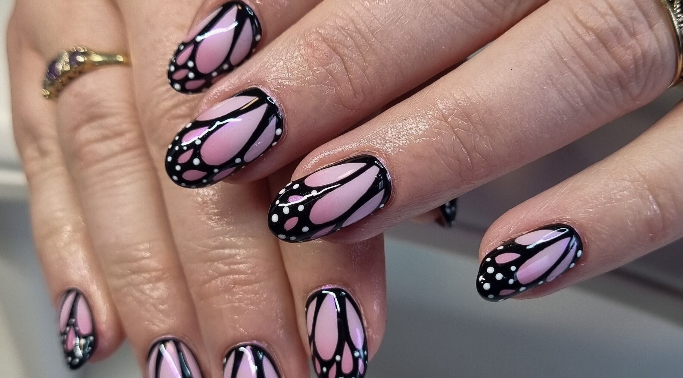 Elegant butterfly-themed nail art at Clawed Nail Studio, Pukekohe, Waikato, NZ, showcasing unique design flair.