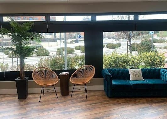 Área de espera con sofás y plantas en Rogelaine Imagen - Las Tablas, Madrid, Comunidad De Madrid, ES.