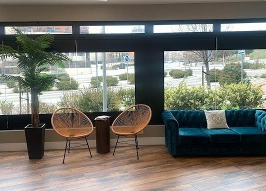 Área de espera con sofás y plantas en Rogelaine Imagen - Las Tablas, Madrid, Comunidad De Madrid, ES.
