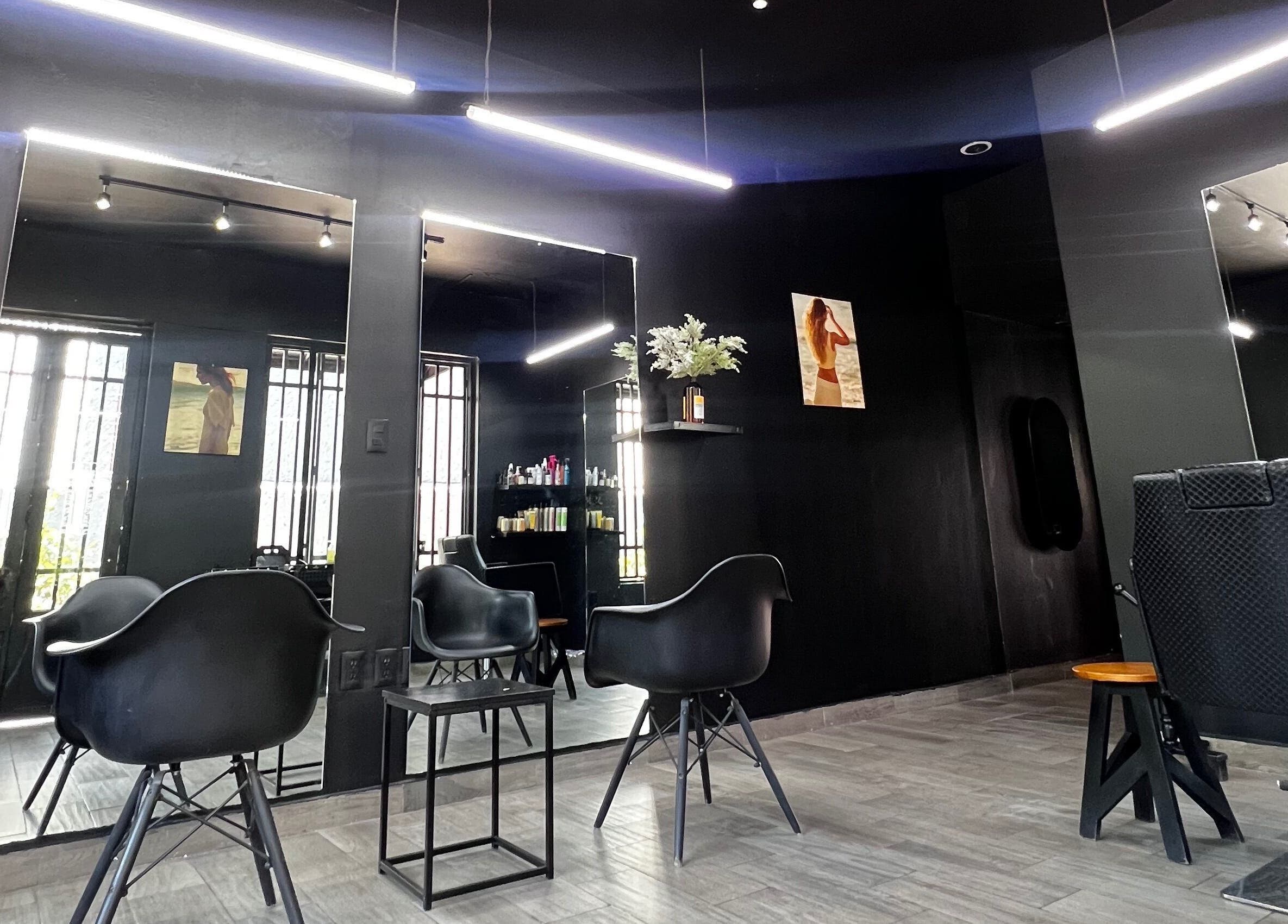 Interior minimalista de Mamba Beauty Studio en Celaya, Guanajuato, MX con sillas modernas y espejos iluminados.