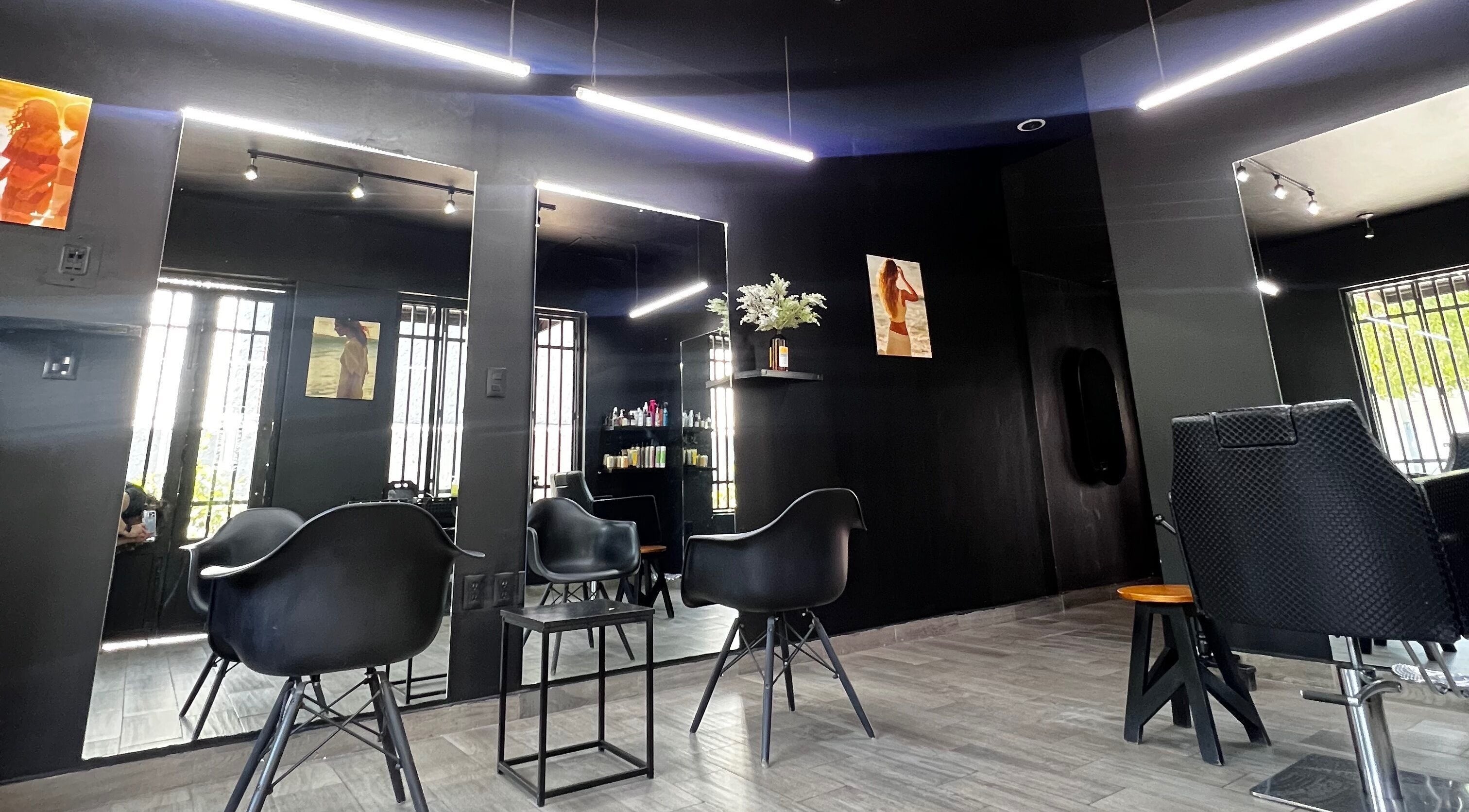 Interior minimalista de Mamba Beauty Studio en Celaya, Guanajuato, MX con sillas modernas y espejos iluminados.