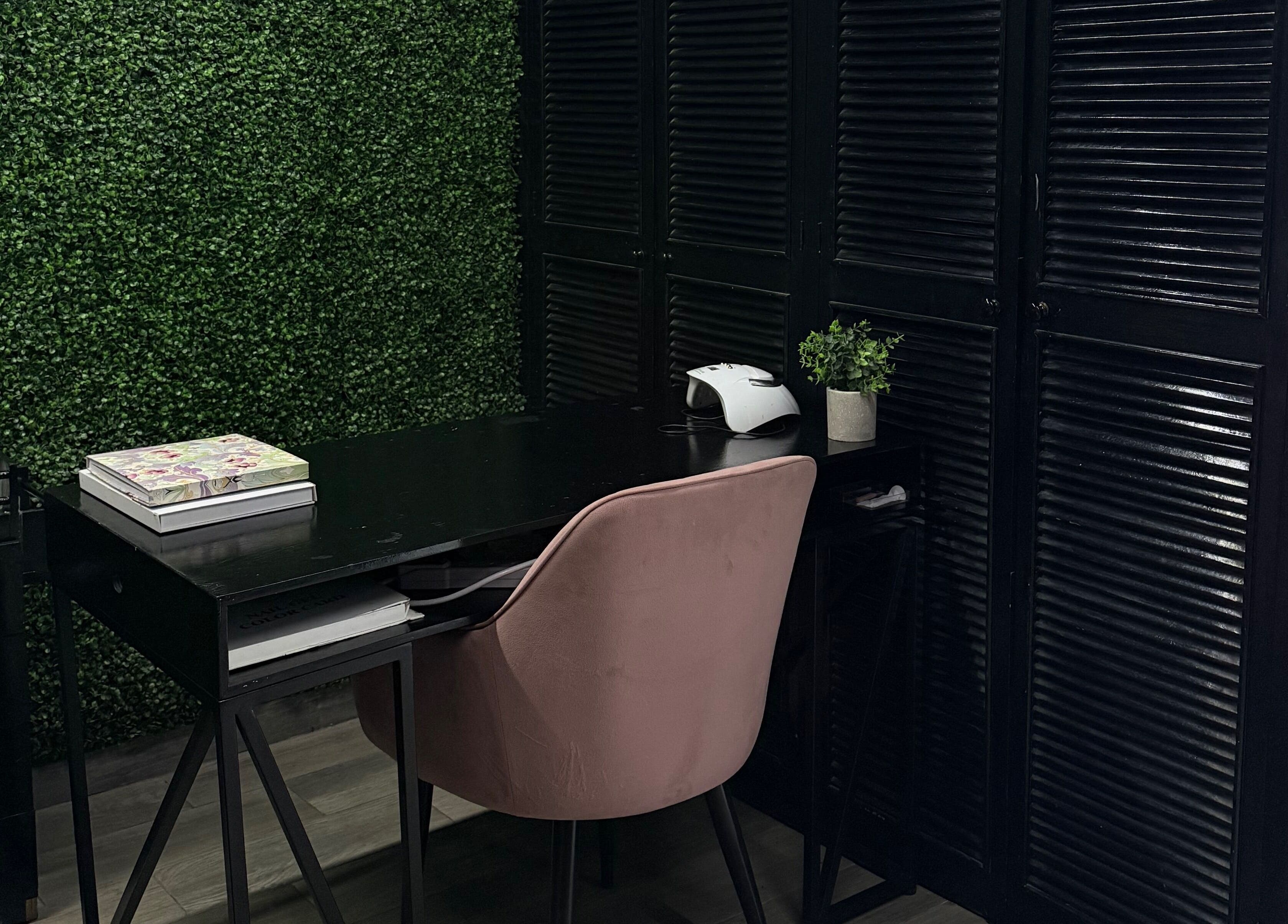 Elegante rincón de Mamba Beauty Studio en Celaya, Guanajuato, MX, con espacio de trabajo moderno y pared verde.