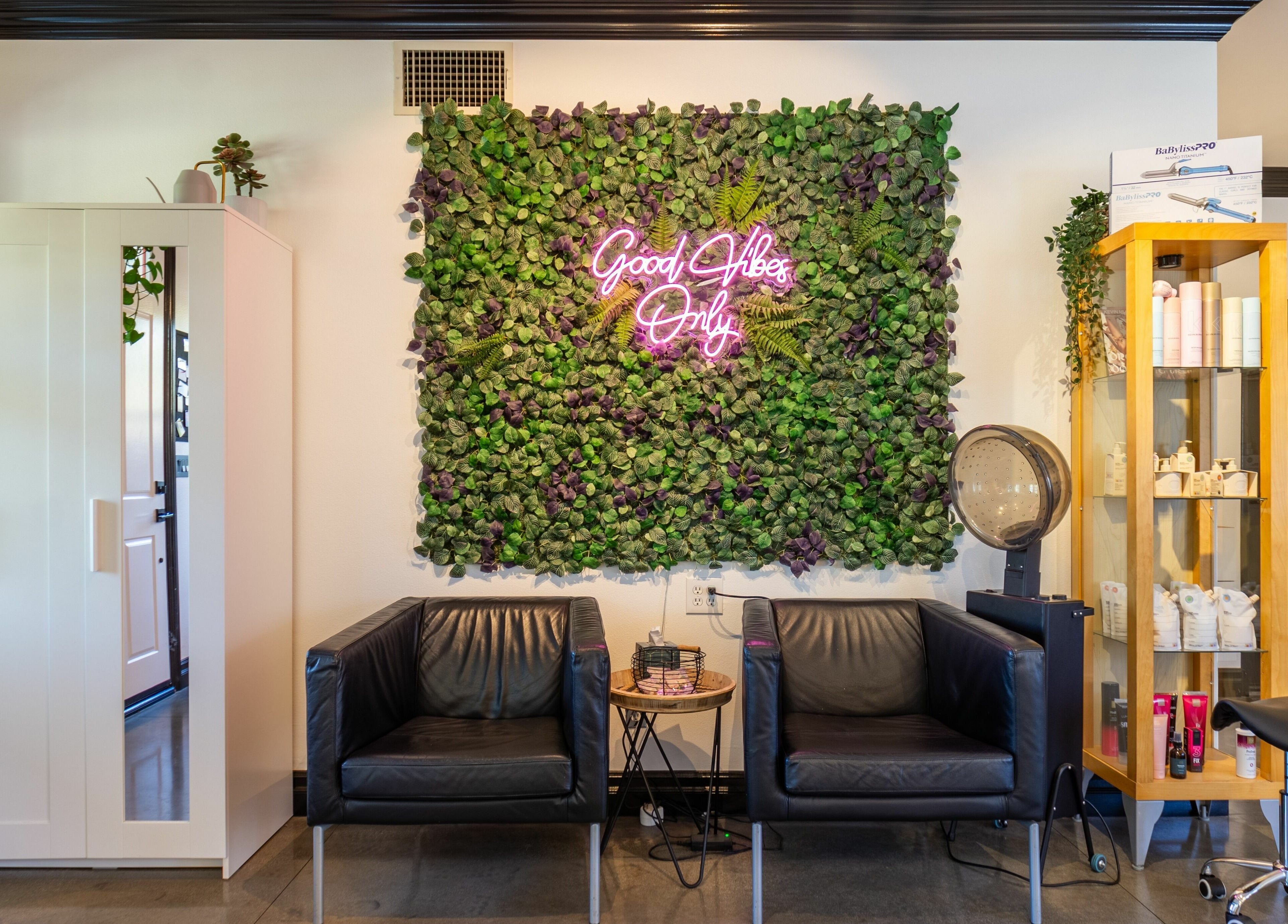 Relaxing waiting area at Red Door Salon with Aimee, featuring lush green wall in Ladera Ranch, California, US.