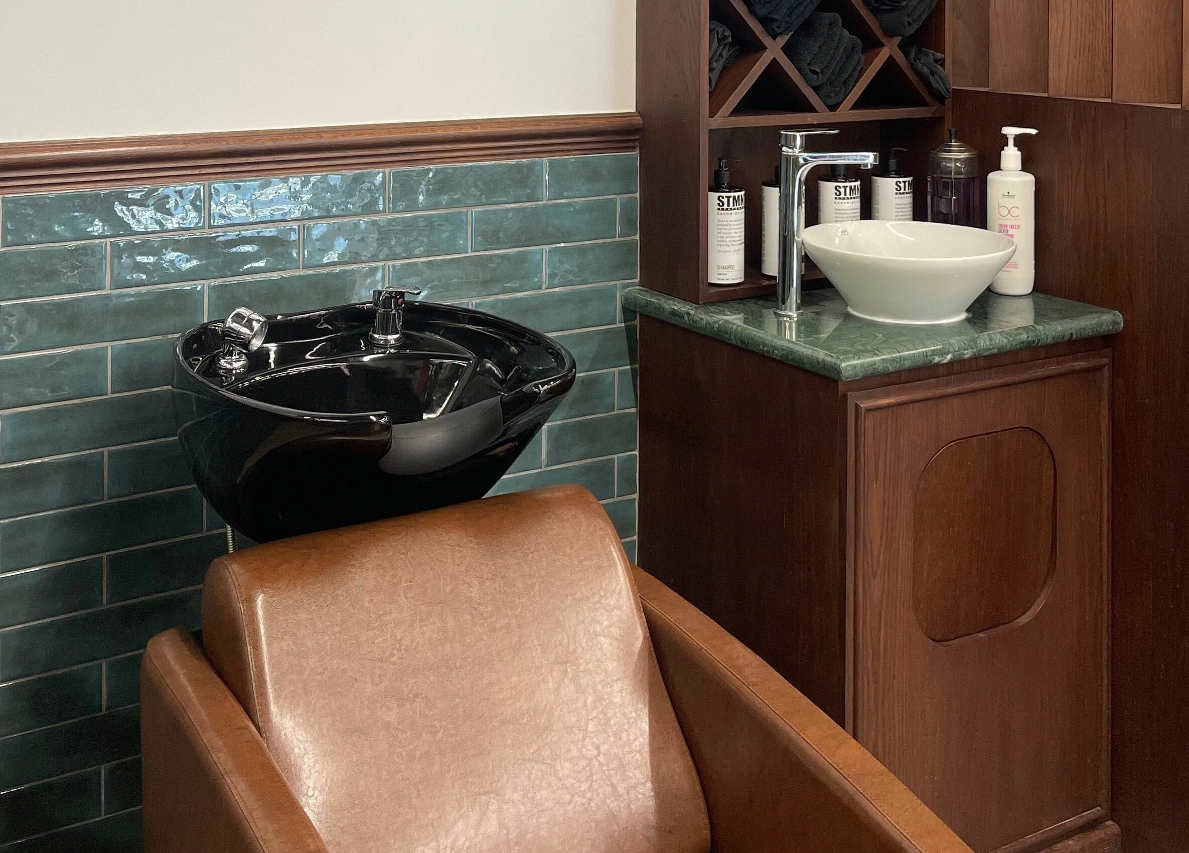 Sleek black wash basin and chair at The Barber Hub Gents on LLC, Dubai, Dubai, AE.