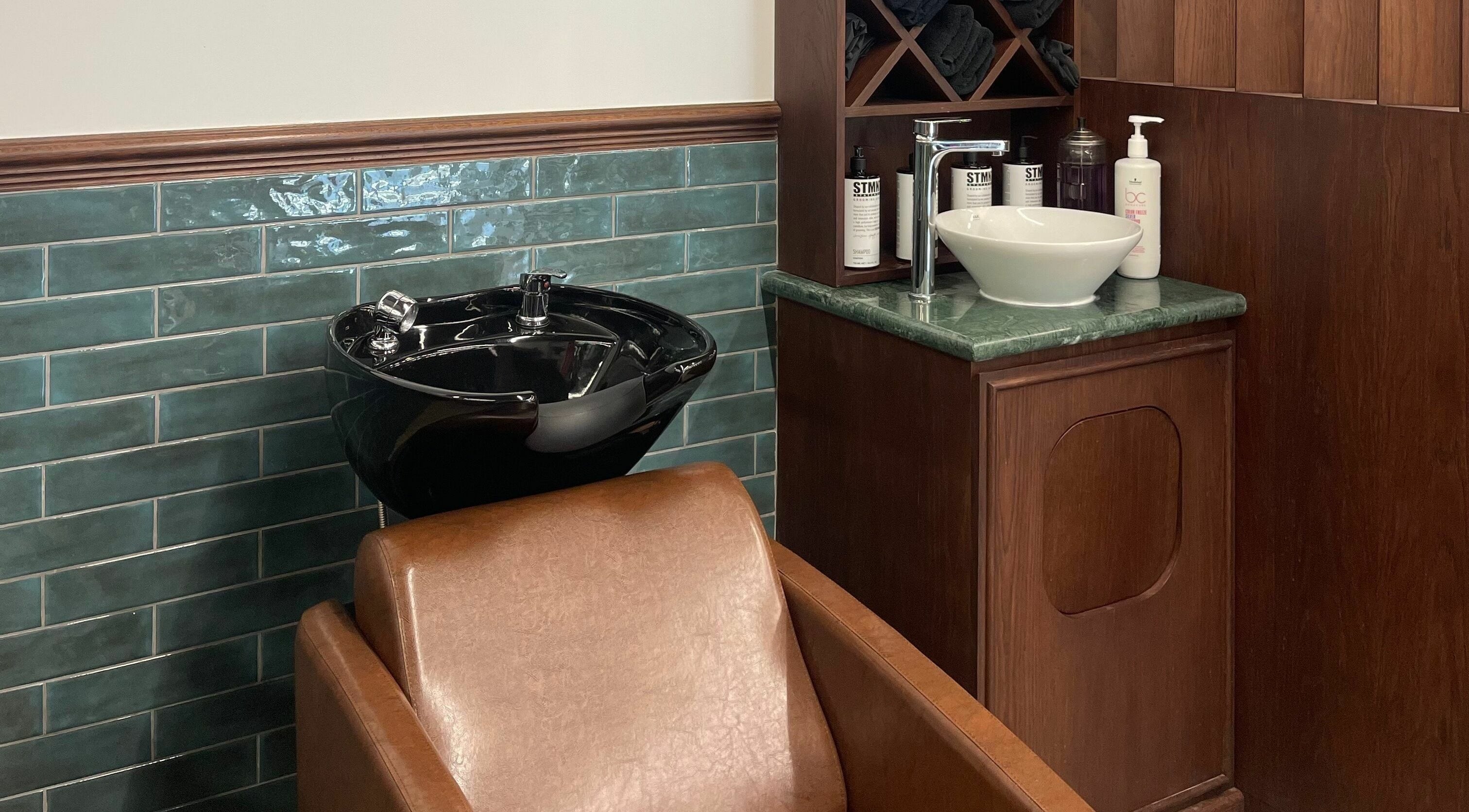 Sleek black wash basin and chair at The Barber Hub Gents on LLC, Dubai, Dubai, AE.
