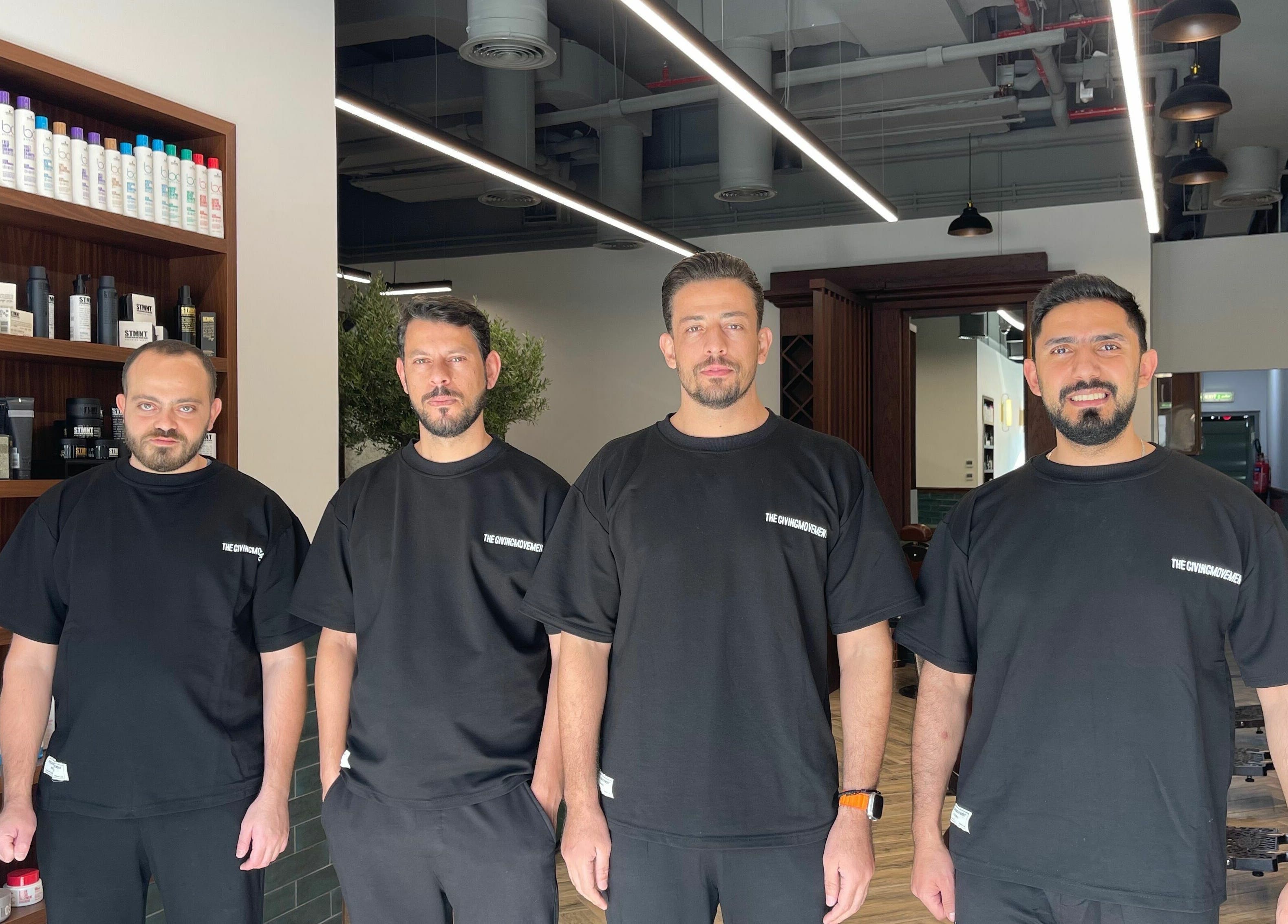 Barbers at The Barber Hub Gents on LLC, Dubai, Dubai, AE, standing in modern salon with products displayed.