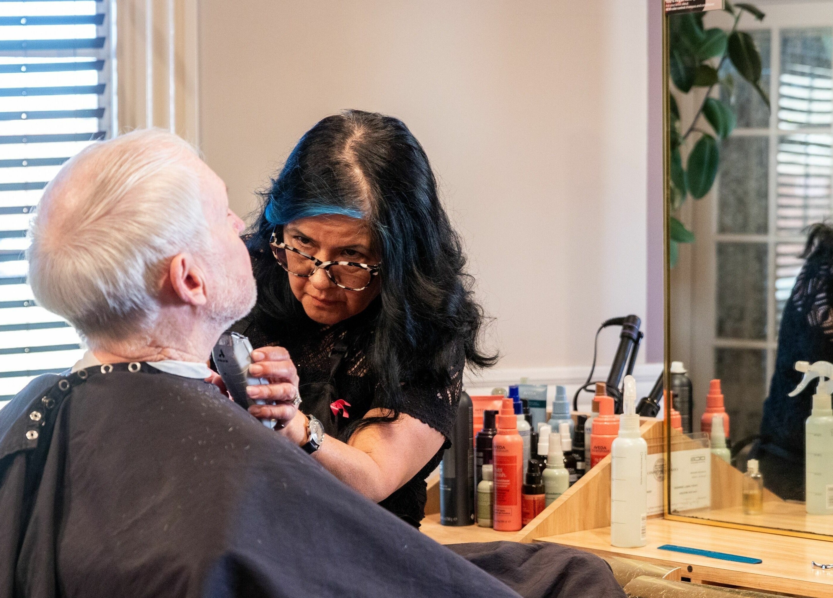 Professional barber grooming a client at Salon Benardo, Fullerton, California, US, showcasing expert care.