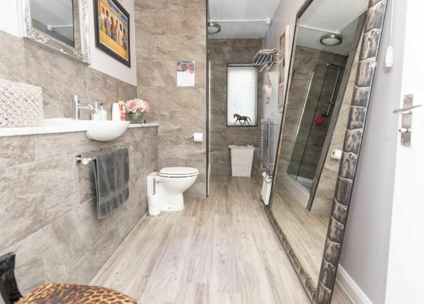 Stylish bathroom interior at High Grade House, Acle, England, GB, featuring modern decor and a large mirror.