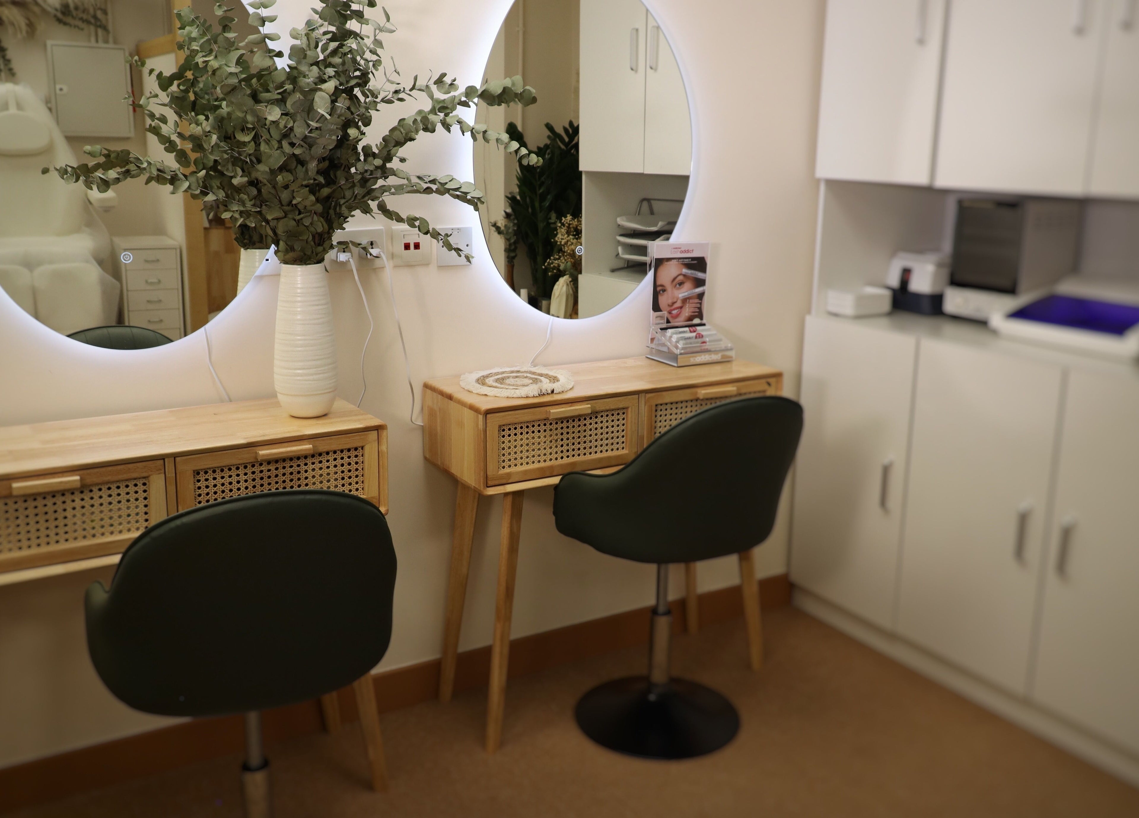 Elegant vanity setup at The Bar, Hong Kong Island, featuring a round mirror and lush greenery.