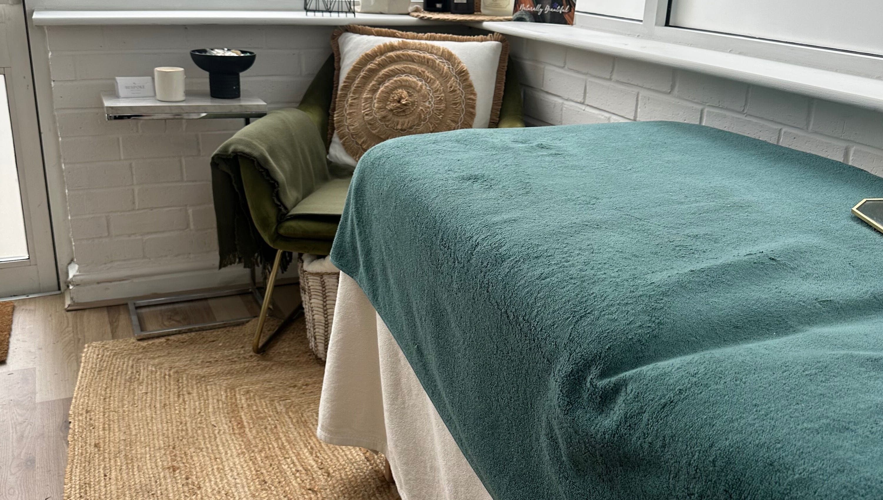 Cozy treatment space at Bespoke Beauty & Skincare, Baildon, England, GB with teal blanket and plush chair.