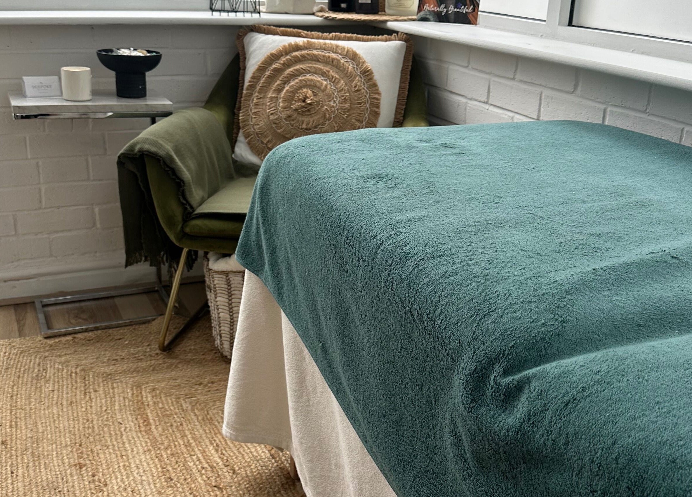 Cozy treatment space at Bespoke Beauty & Skincare, Baildon, England, GB with teal blanket and plush chair.