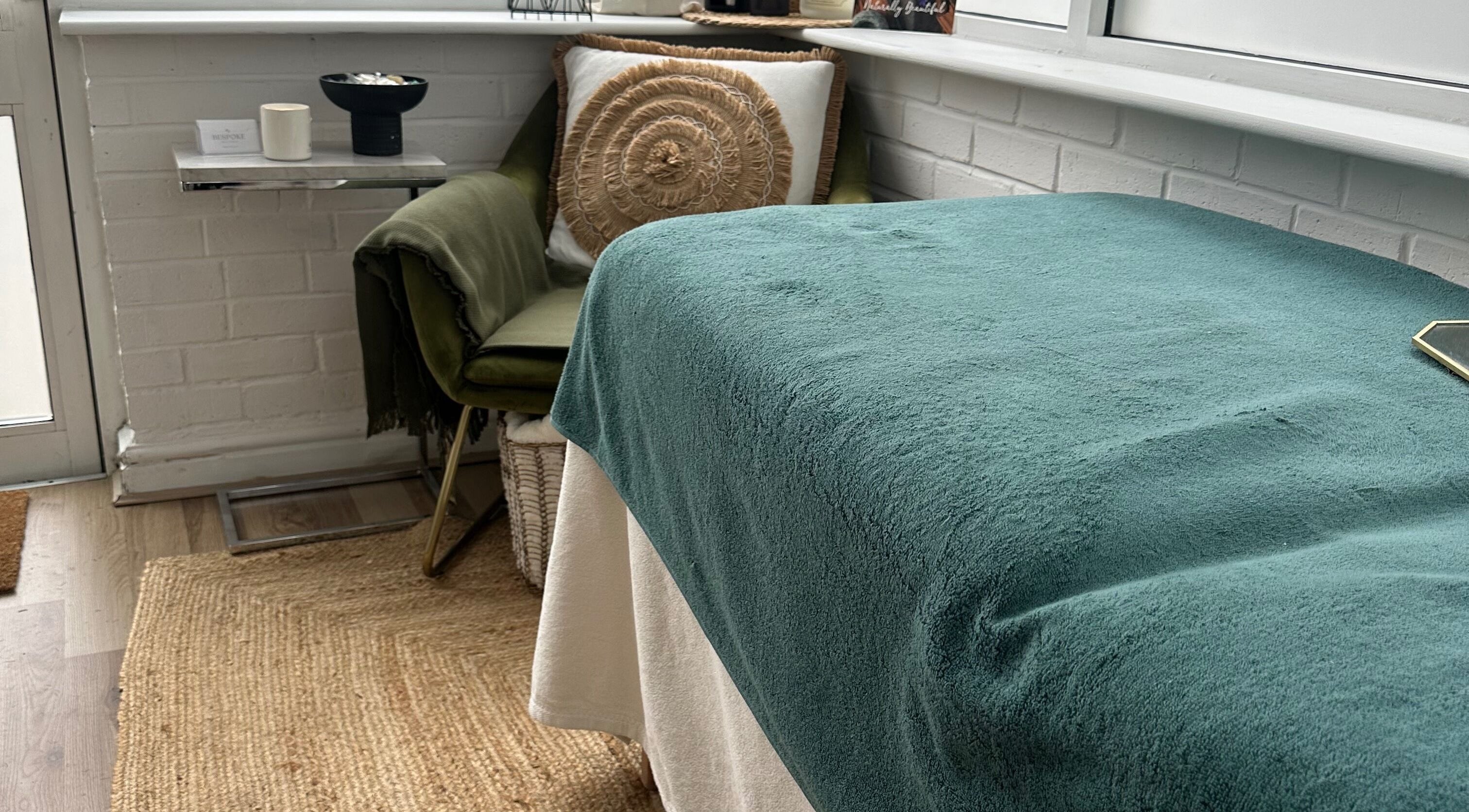 Cozy treatment space at Bespoke Beauty & Skincare, Baildon, England, GB with teal blanket and plush chair.