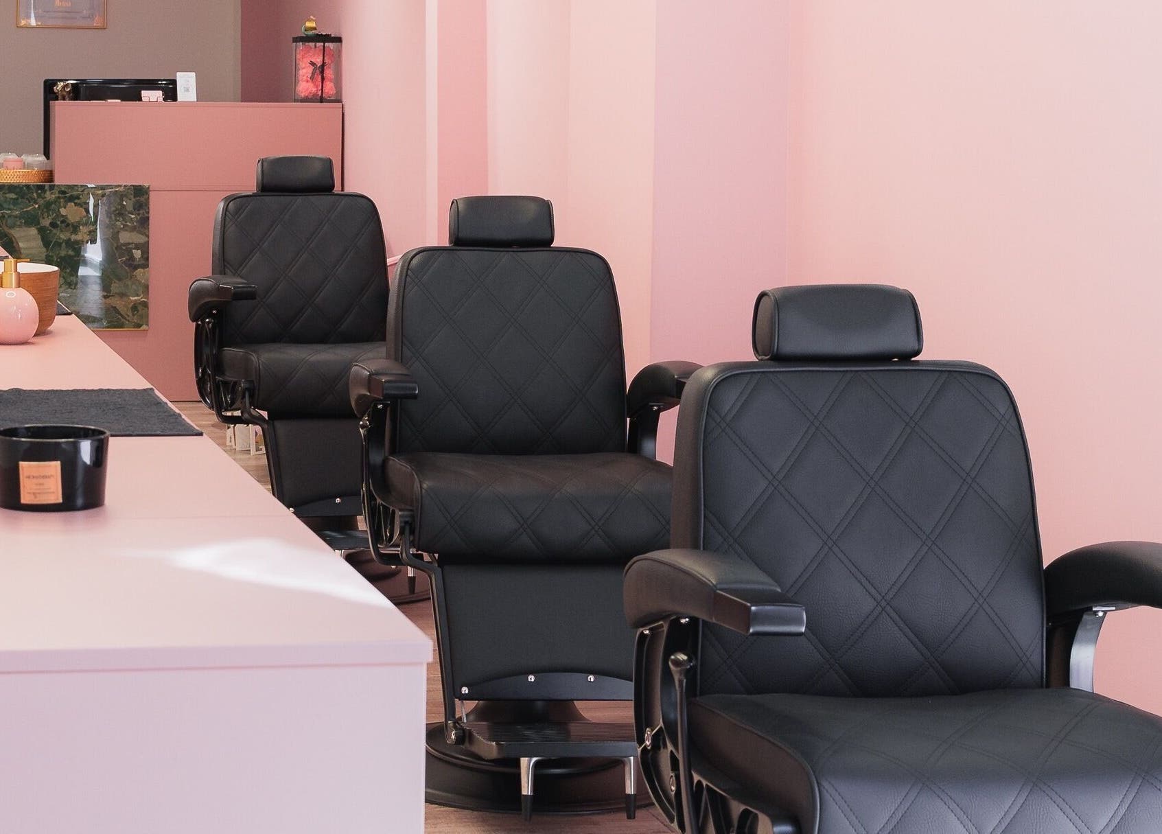 Πολυτελείς μαύρες καρέκλες στο Aster The Beauty Brow Bar, Πειραιάς, GR σε κομψό ροζ χώρο.