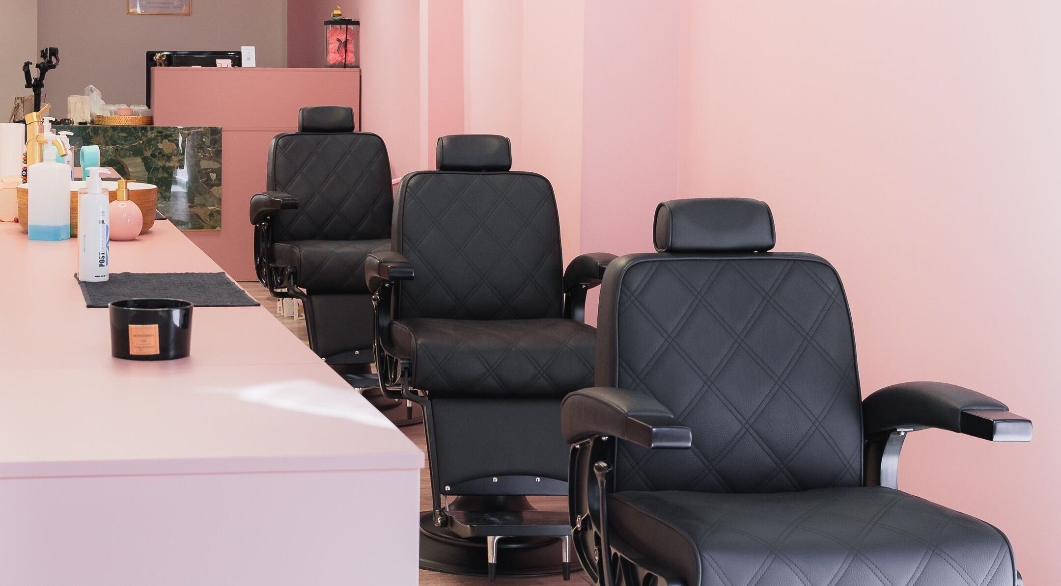 Πολυτελείς μαύρες καρέκλες στο Aster The Beauty Brow Bar, Πειραιάς, GR σε κομψό ροζ χώρο.