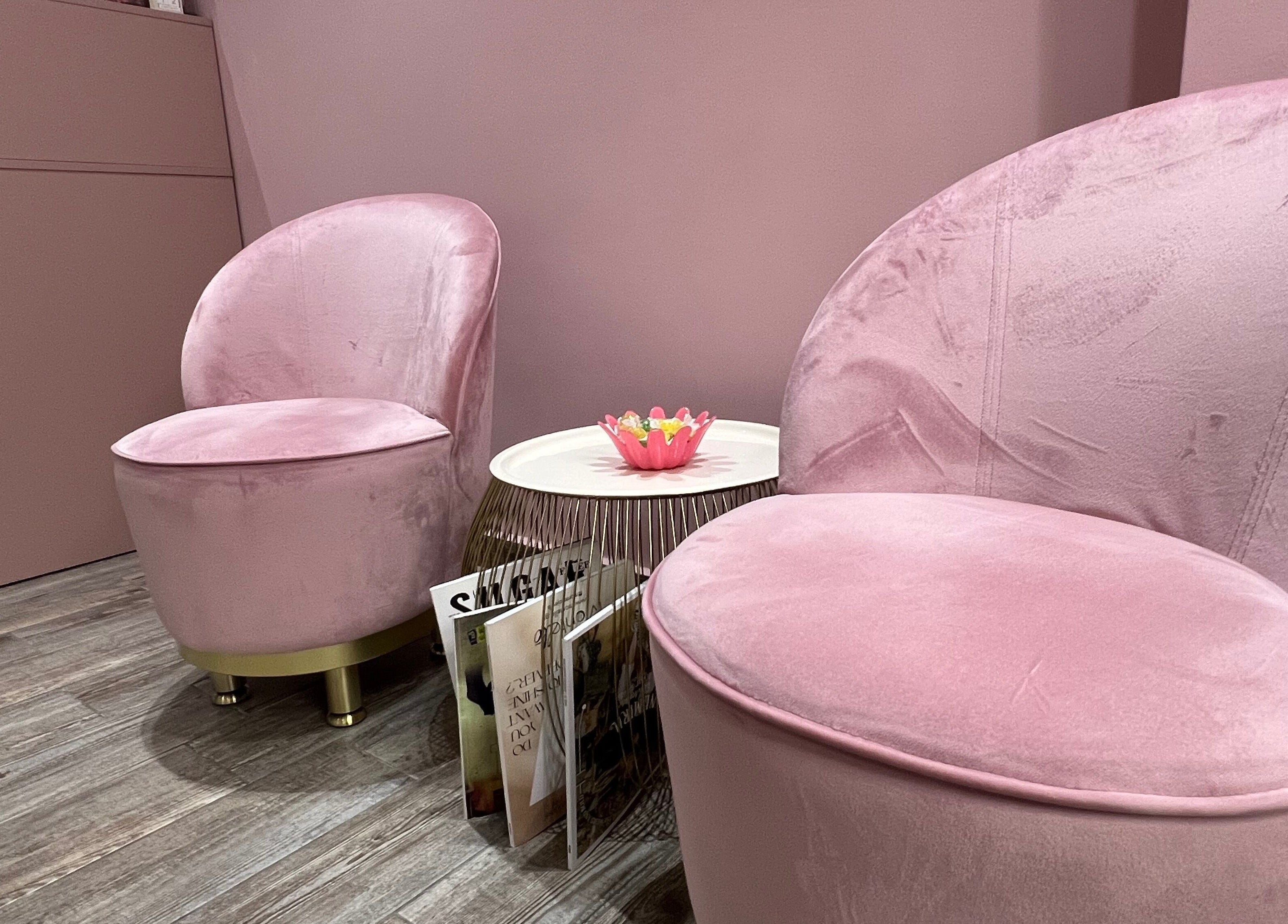 Ροζ καθίσματα στο Aster The Beauty Brow Bar, Πειραιας, GR με μοντέρνα διακόσμηση και περιοδικά.