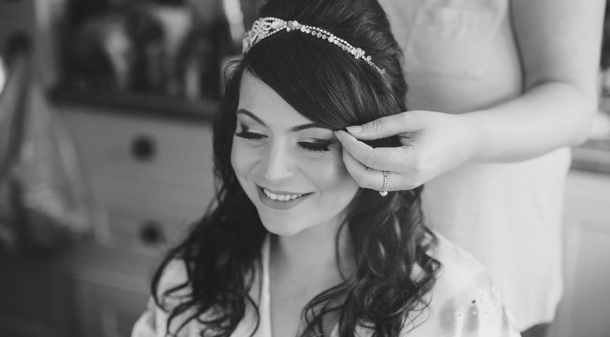 Bride smiling while hairstylist adjusts hair at Sabrina's Hair Lounge, Havant, England, GB.