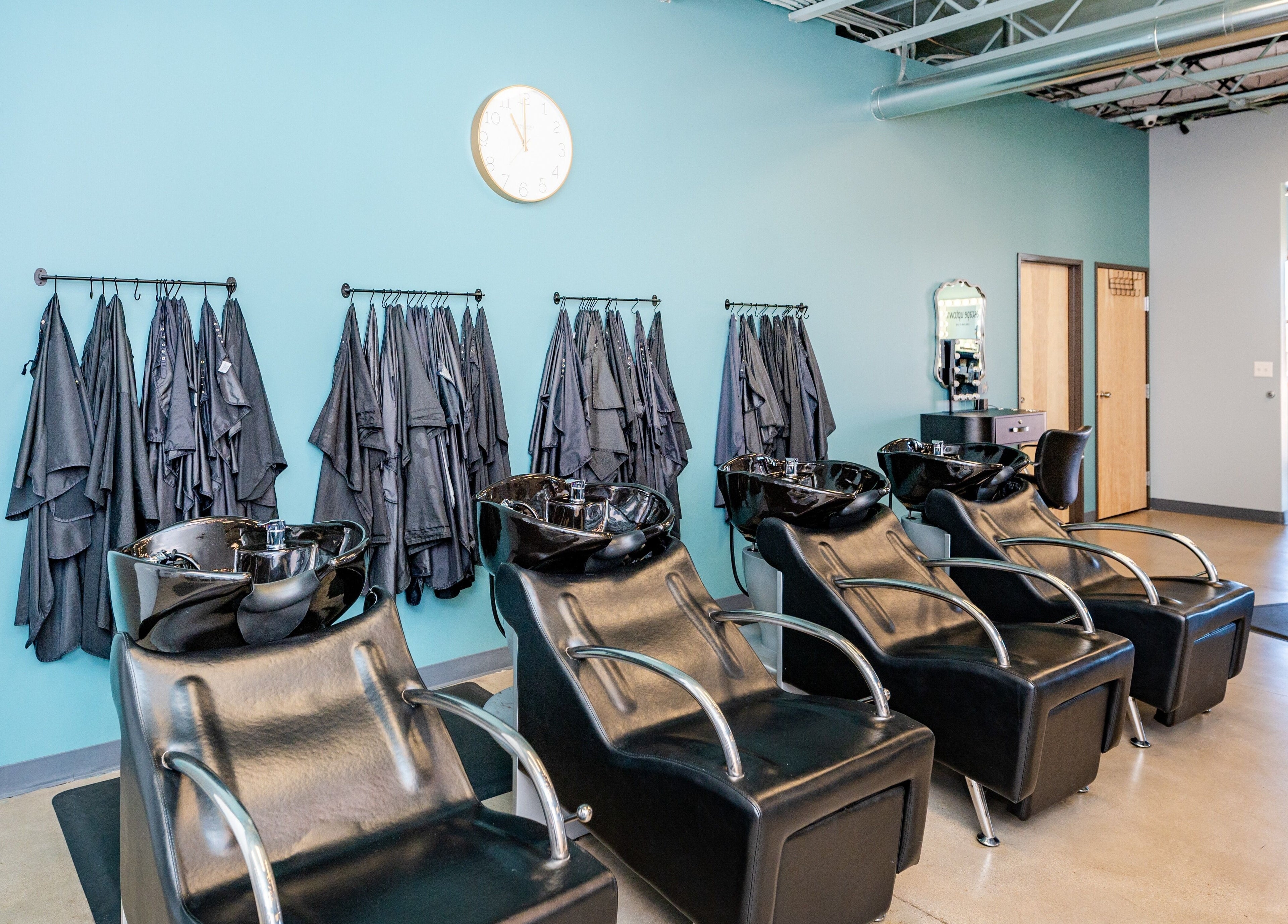 Spacious salon with black wash stations at Escape Uptown, Erie, Colorado, US, for a relaxing experience.