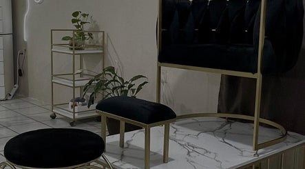 Elegante sala de espera en 𝐈 𝐍 The Beauty Room •Guadalajara•, Zapopan, Jalisco, MX, con sillas negras y plantas.