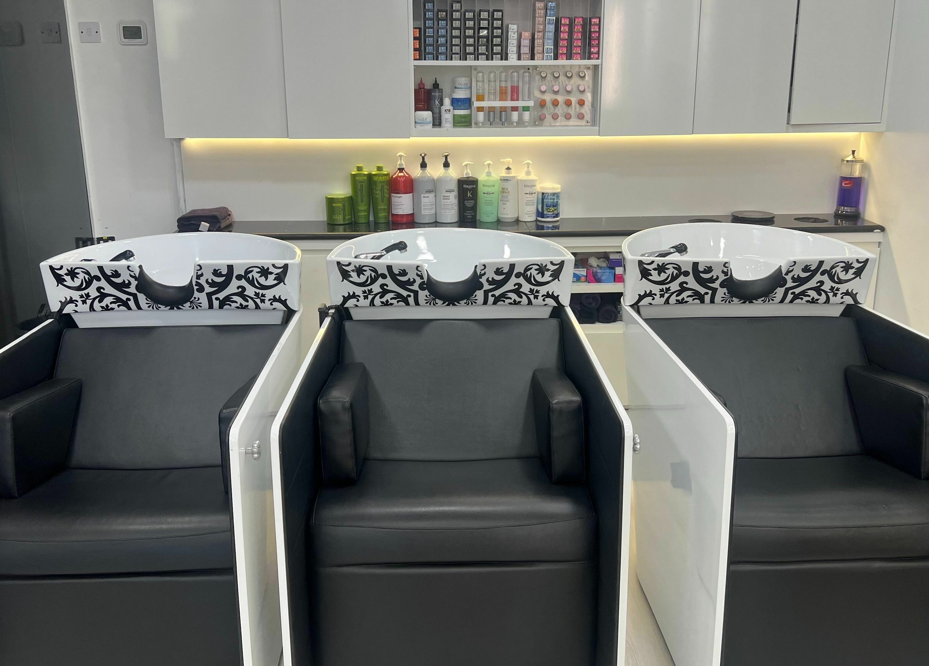 Luxury wash stations at Karim And Amin Hair and Beauty Salon | Tecom, Dubai. Stylish salon chairs and sinks.