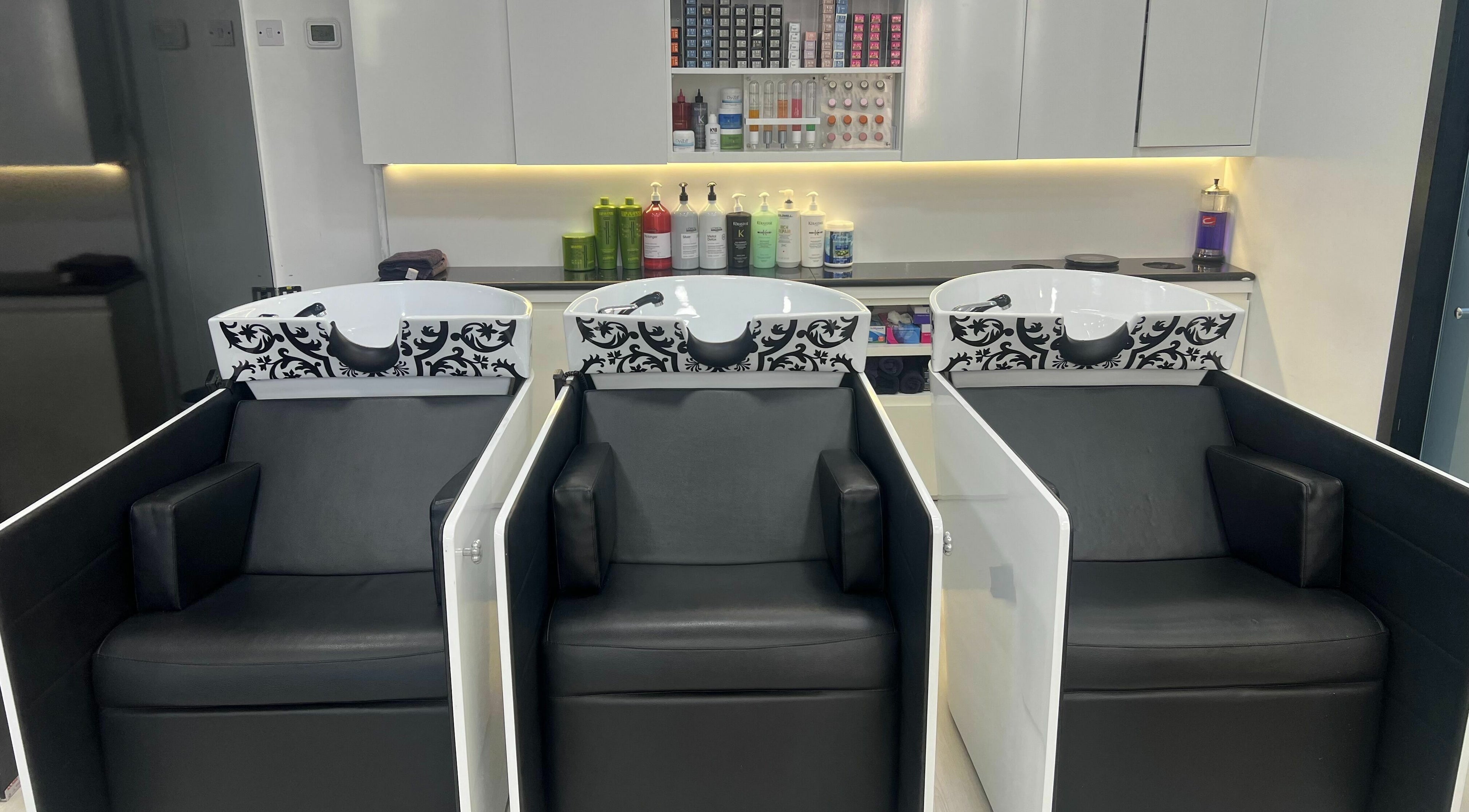 Luxury wash stations at Karim And Amin Hair and Beauty Salon | Tecom, Dubai. Stylish salon chairs and sinks.