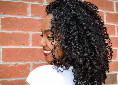 Bright smile with stunning curls at Natural Curly Haven, Toronto, Ontario, CA. Embrace curly beauty.