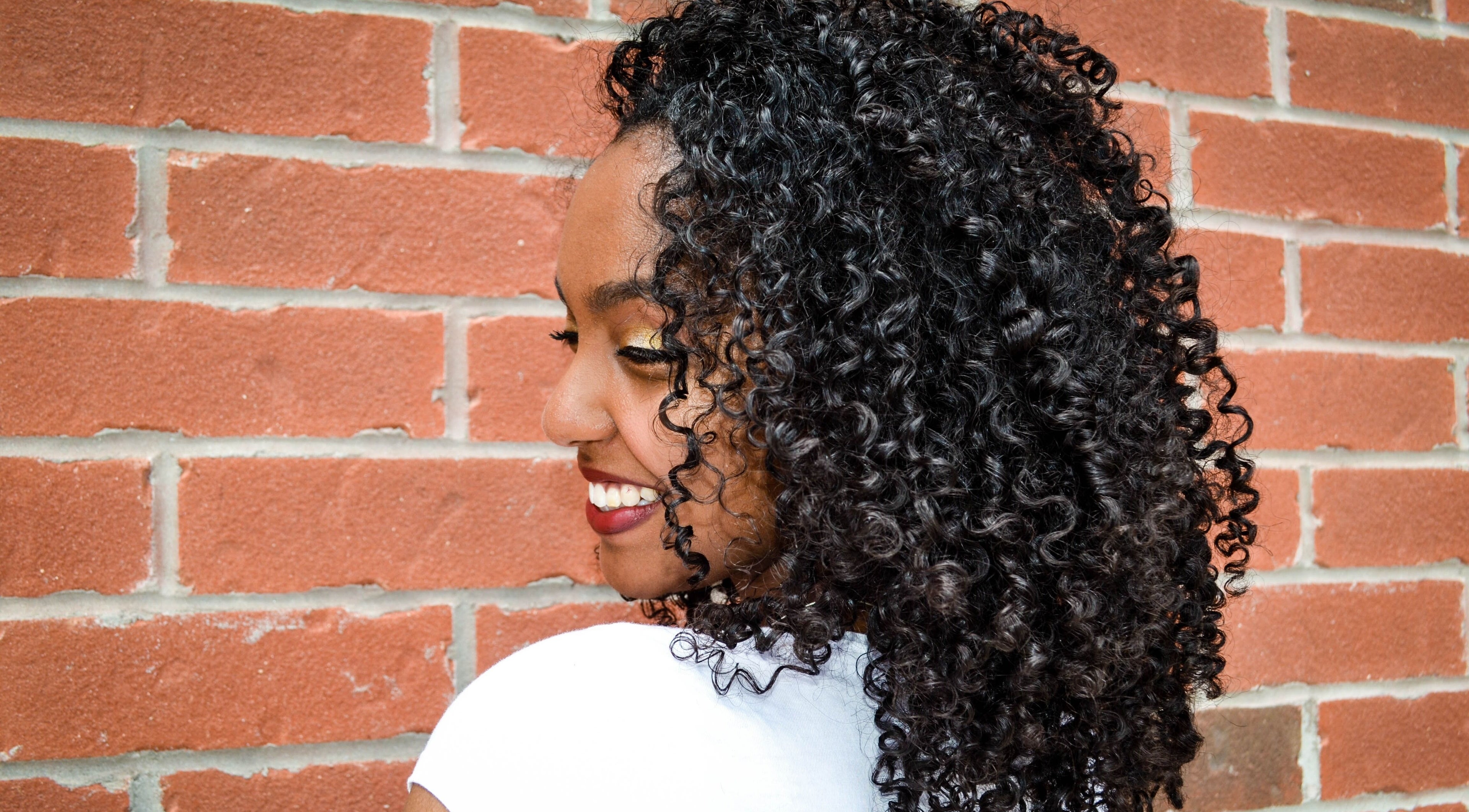 Bright smile with stunning curls at Natural Curly Haven, Toronto, Ontario, CA. Embrace curly beauty.