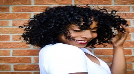 Smiling woman with curly hair at Natural Curly Haven, Toronto, Ontario, CA, embracing natural beauty.