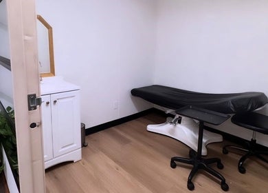 Serene treatment room at MMBW Industry, Ventura, California, US with massage bed and minimalist decor.