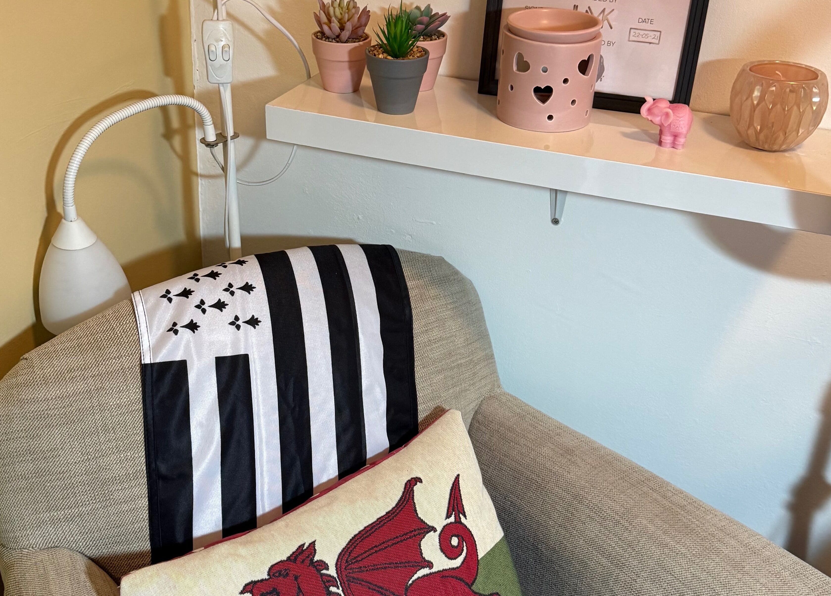 Leeswood venue's cozy corner with plush armchair in Leeswood, Wales, GB. Features decorative pillows and shelf.