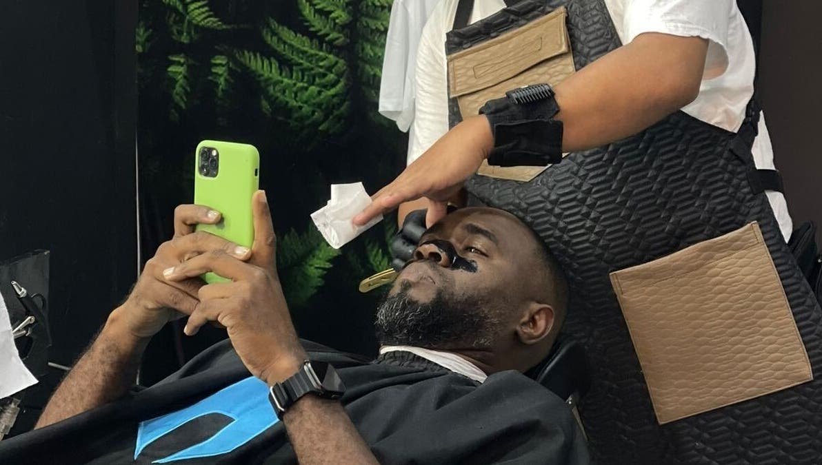 Cliente relajado en Saavedra Barber, Panamá, Provincia De Panamá, PA, recibiendo servicio de barbería.