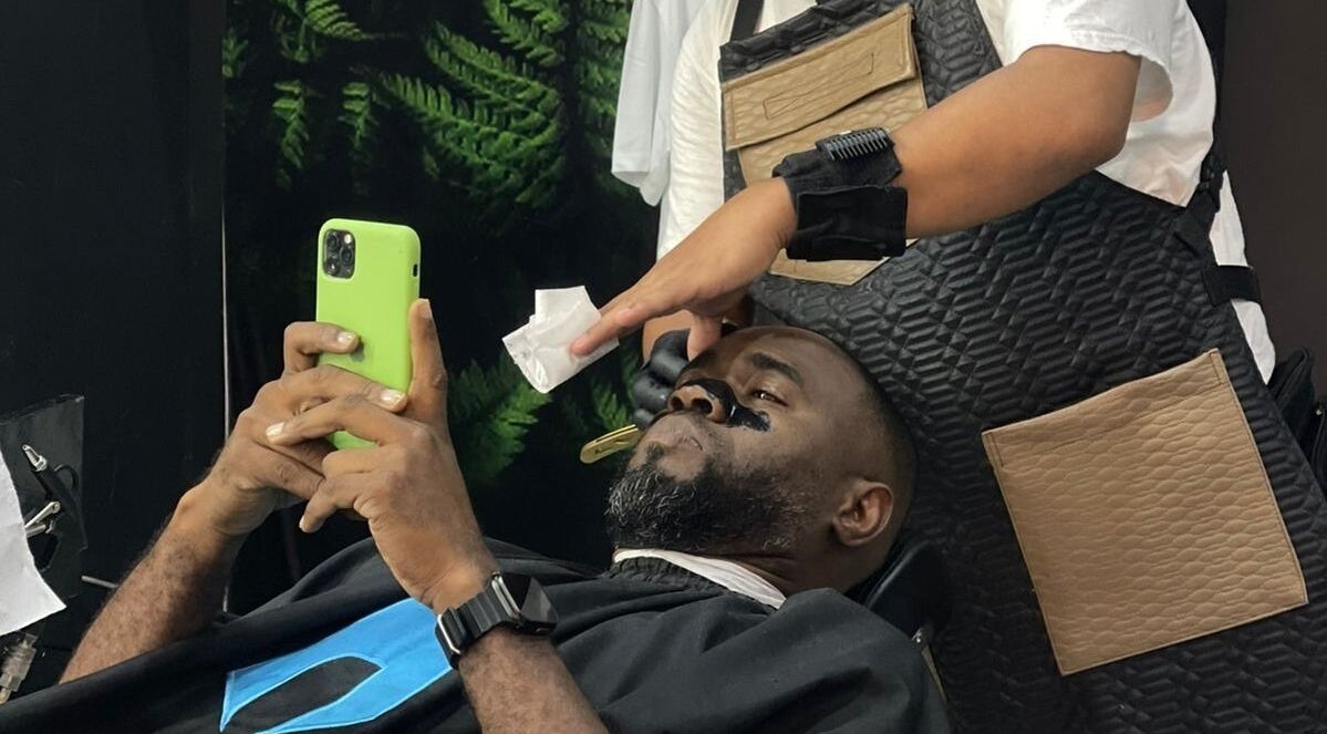 Cliente relajado en Saavedra Barber, Panamá, Provincia De Panamá, PA, recibiendo servicio de barbería.