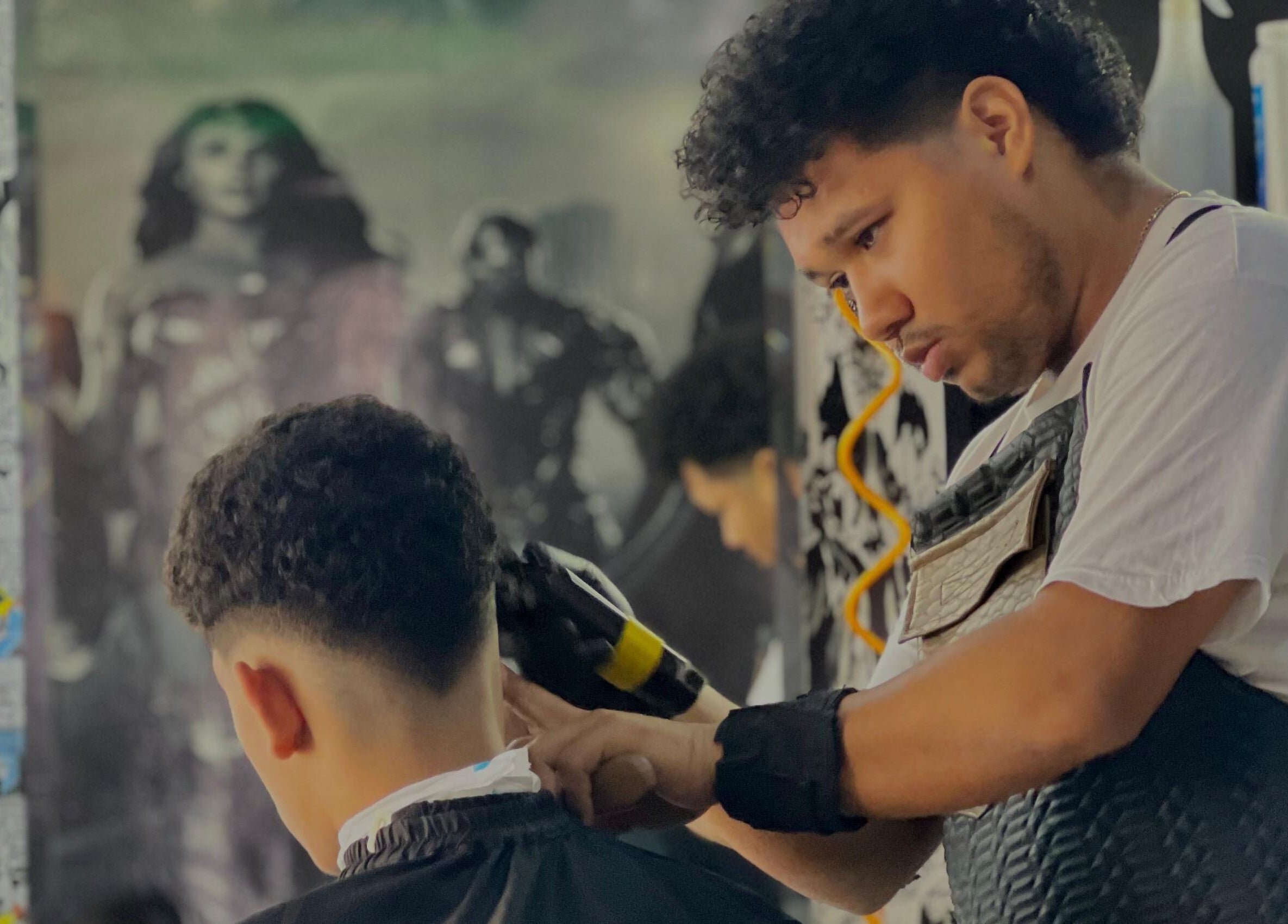 Barbero en Saavedra Barber, Panamá, Provincia De Panamá, PA, cortando el cabello a un cliente con precisión.