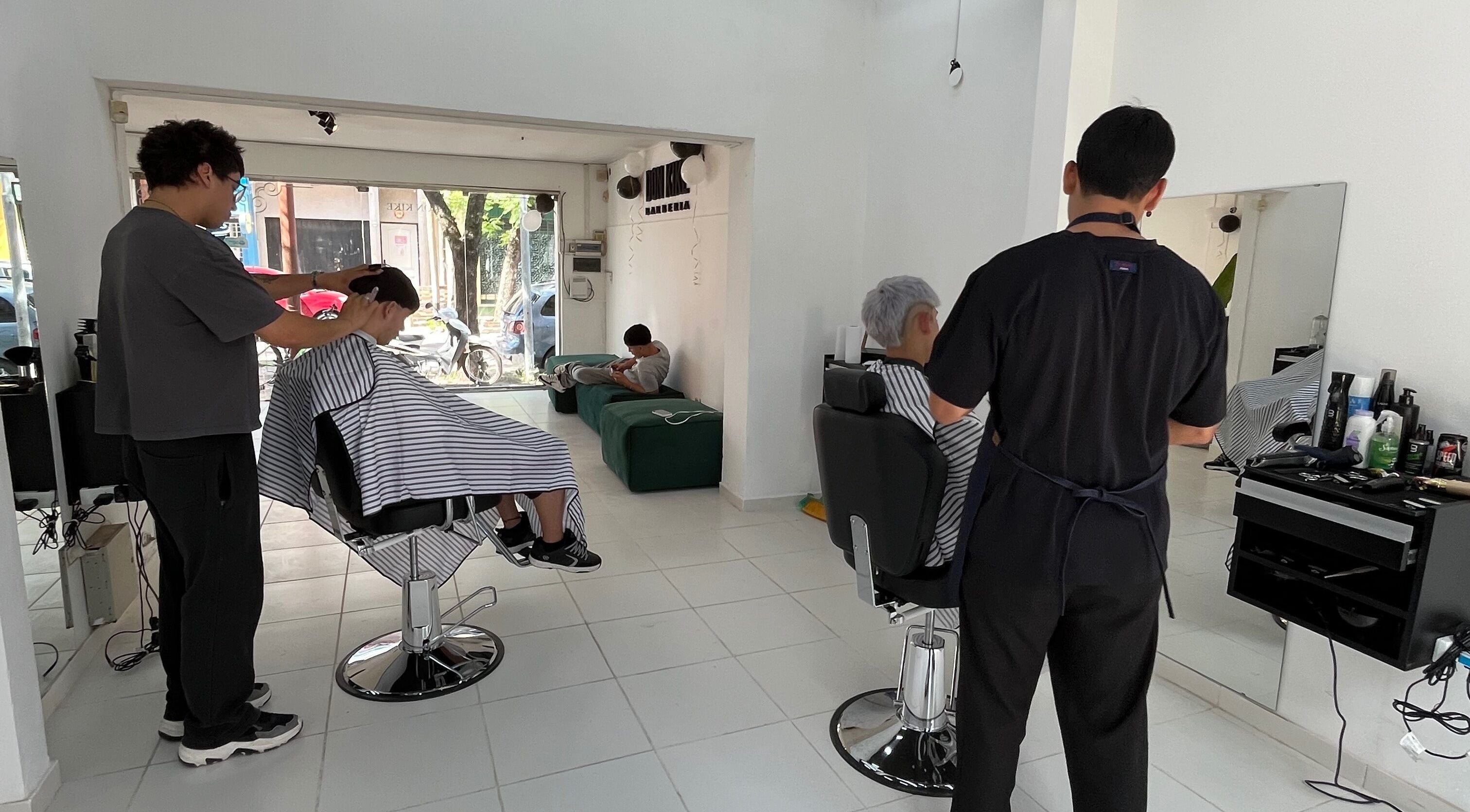 Interior de Don Kike Barberia - Gral. Rodríguez, Provincia De Buenos Aires, AR, con clientes recibiendo cortes de pelo.