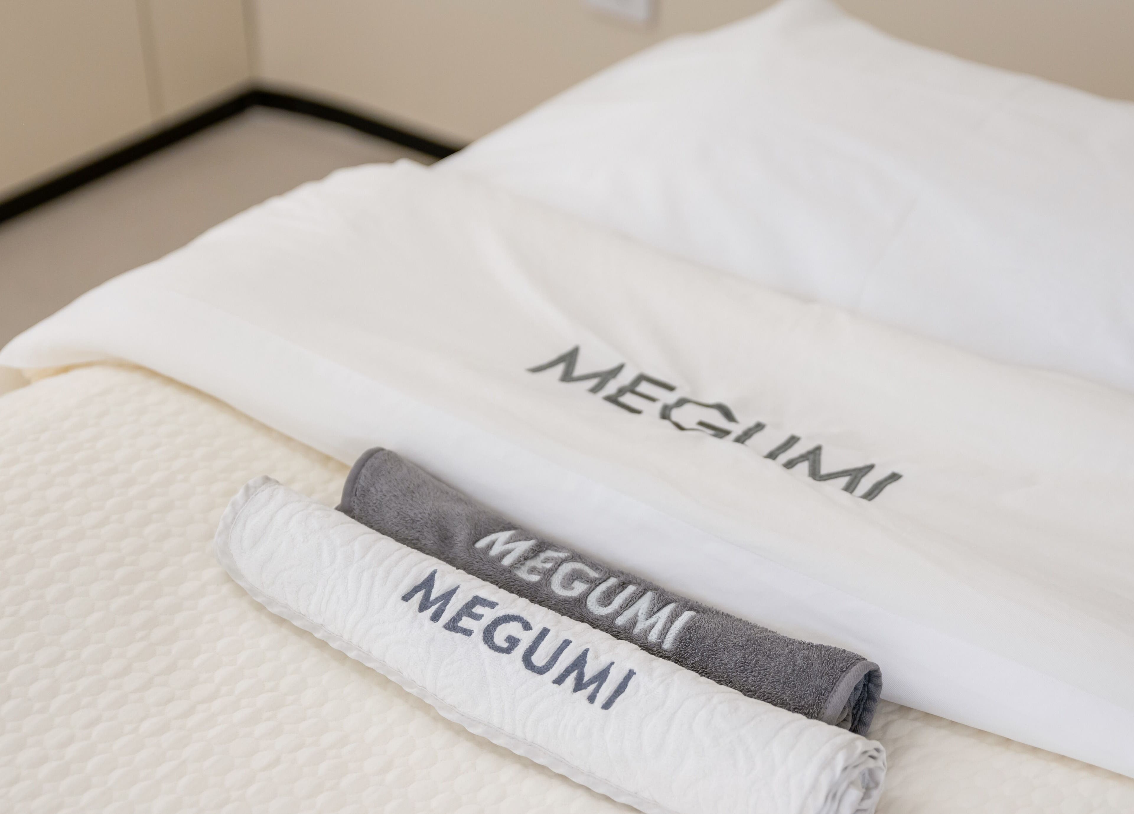 Luxury towels branded MEGUMI GLOBAL in a serene spa setting, Sydney, New South Wales, AU.