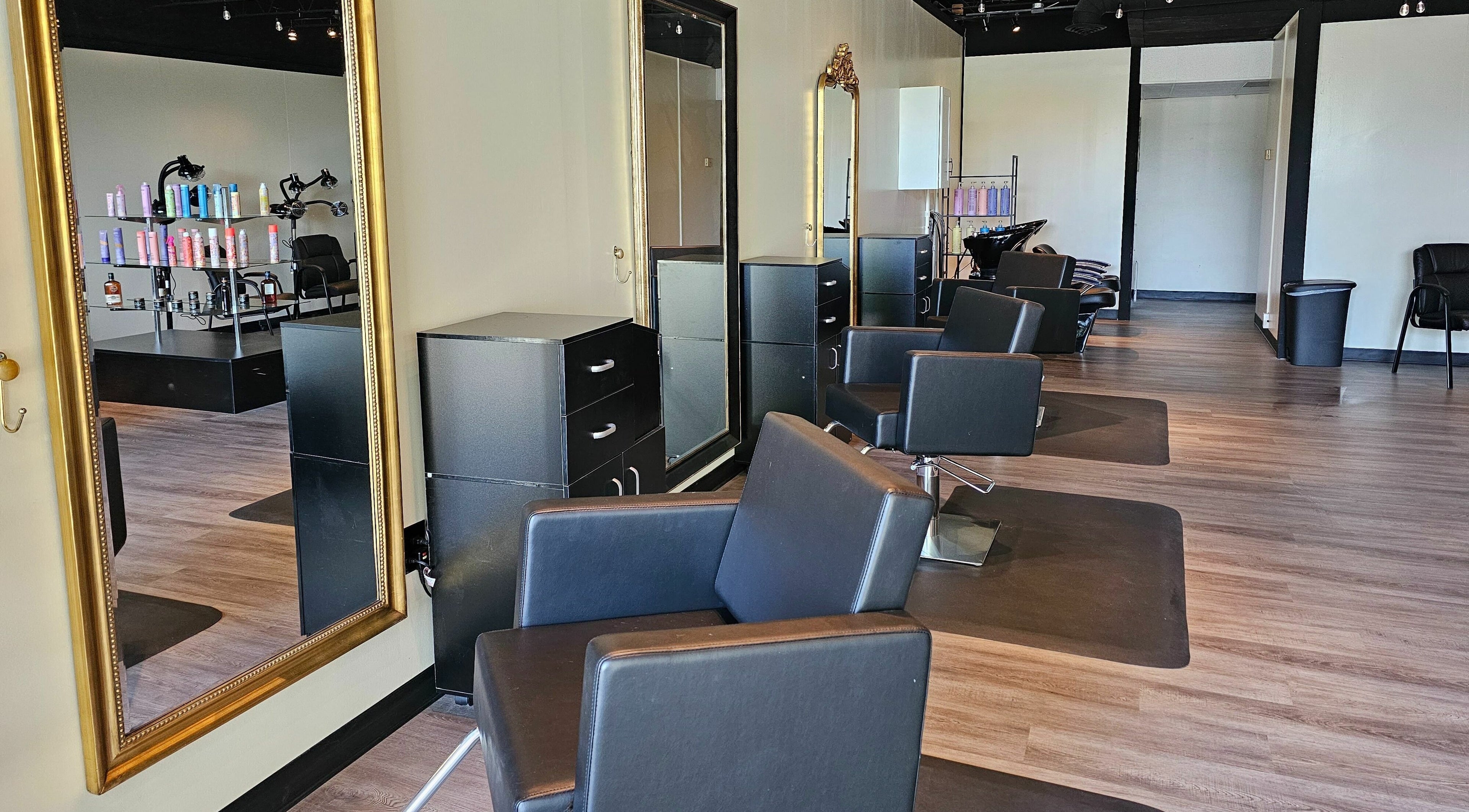 Modern interior of Mythic Hair Salon in Birmingham, Alabama. Stylish chairs and mirrors enhance the sleek atmosphere.