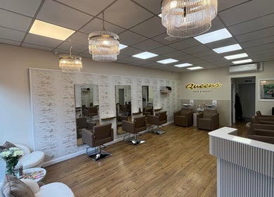 Sleek interior of Queens Hair & Beauty in Bristol, England, GB with modern salon chairs and ambient lighting.
