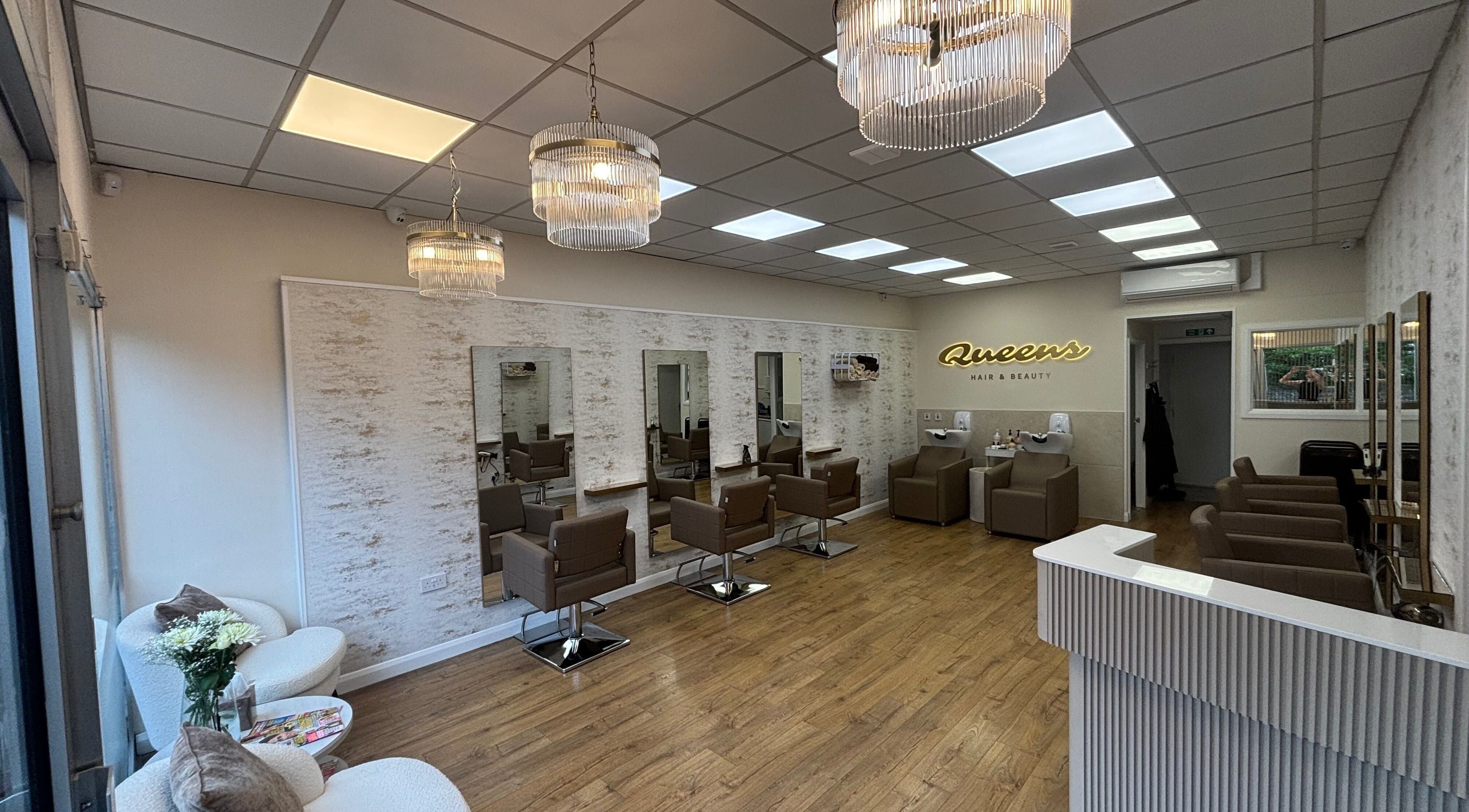 Sleek interior of Queens Hair & Beauty in Bristol, England, GB with modern salon chairs and ambient lighting.