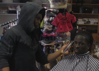Mjay The Barber in Nottingham, England, GB, giving a precise haircut with electric clippers.